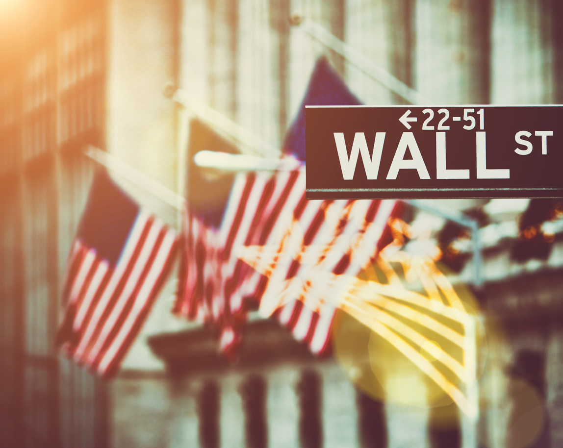 Wall street sign in New York with New York Stock Exchange background