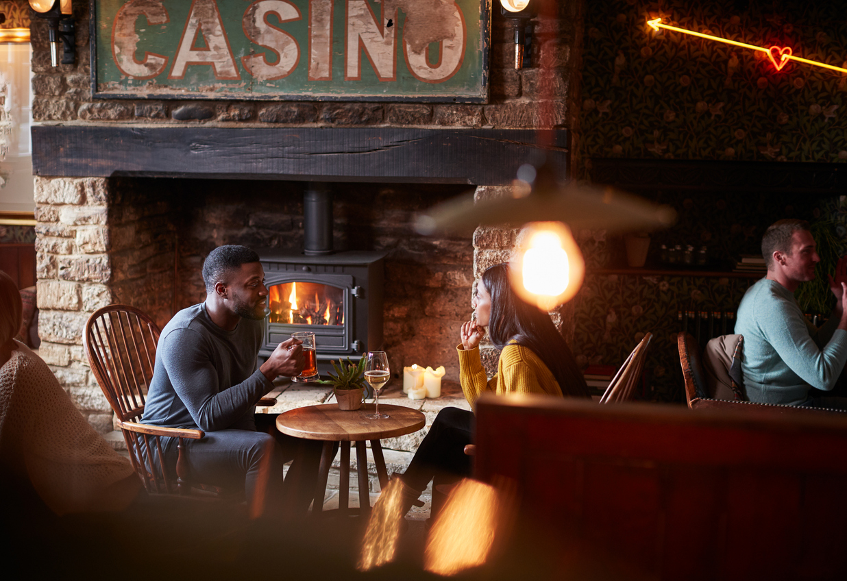 Couple Meeting For Lunchtime Drinks In Traditional English Pub Making A Toast
