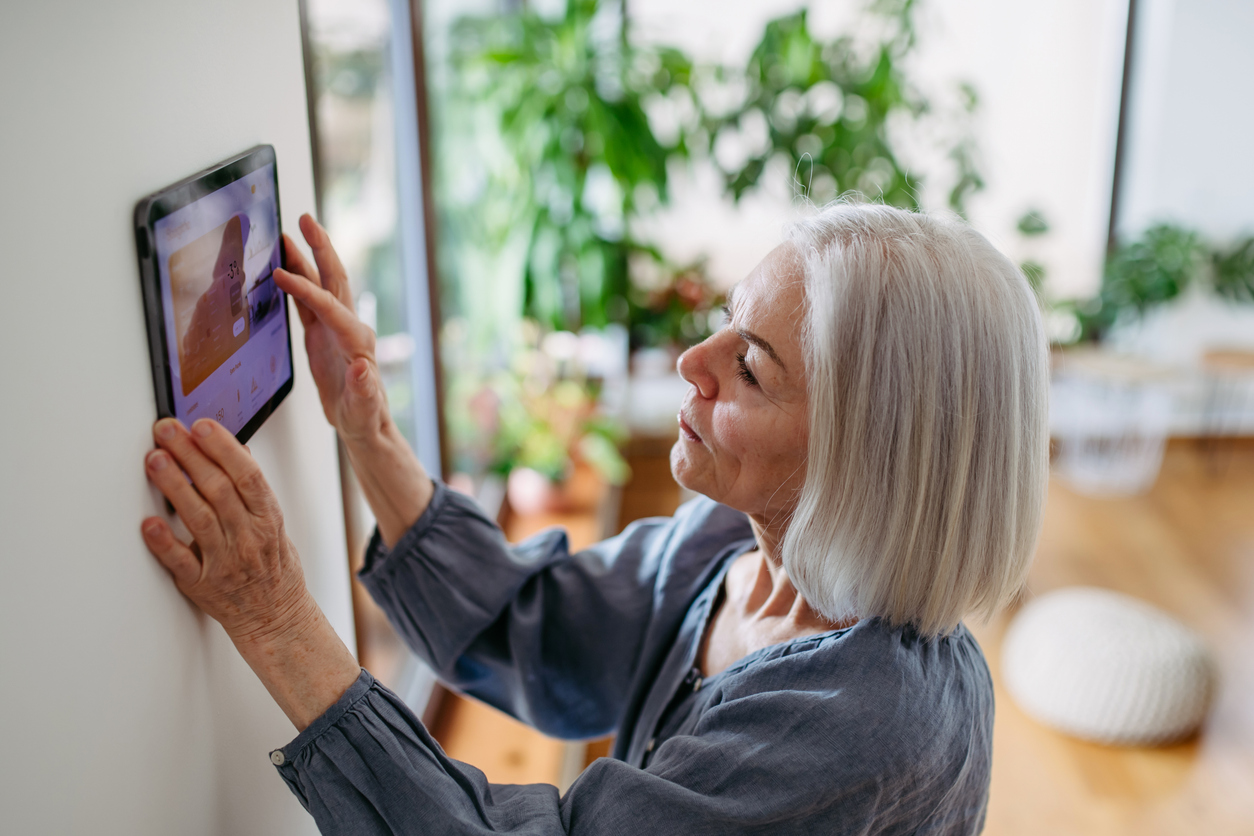 Elderly woman with smart thermostat