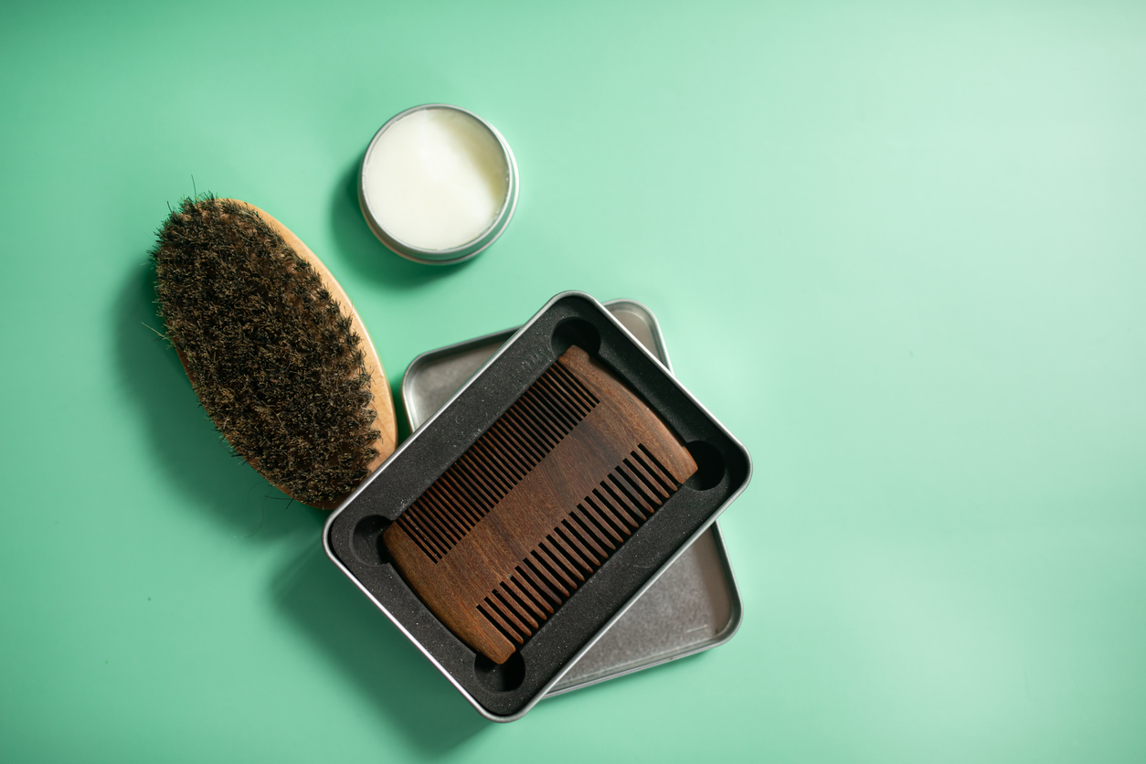 Close up view of beard kit with wax, comb and brush.