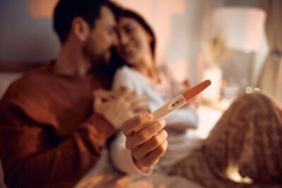 Close up of couple with positive pregnancy test.