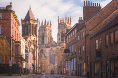 orning golden light on the historic old town of York along Museum St. looking towards York Minster Cathedral.
