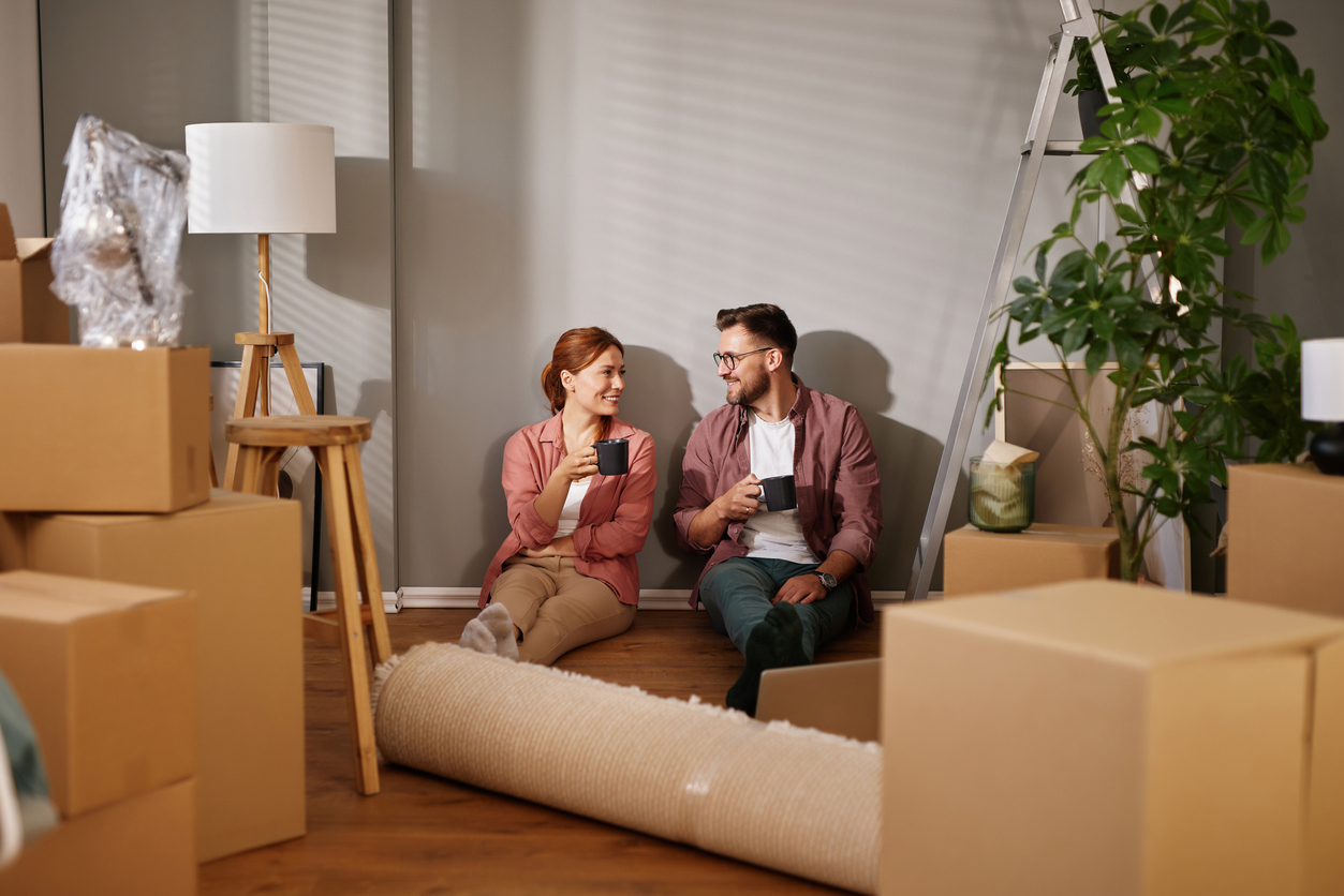Happy couple drinking coffee while taking a break from moving into new home