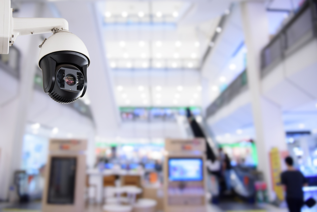 A high-angle photograph of a modern security camera system in a shopping mall, effectively monitoring the premises and ensuring safety and security for all shoppers in the area.