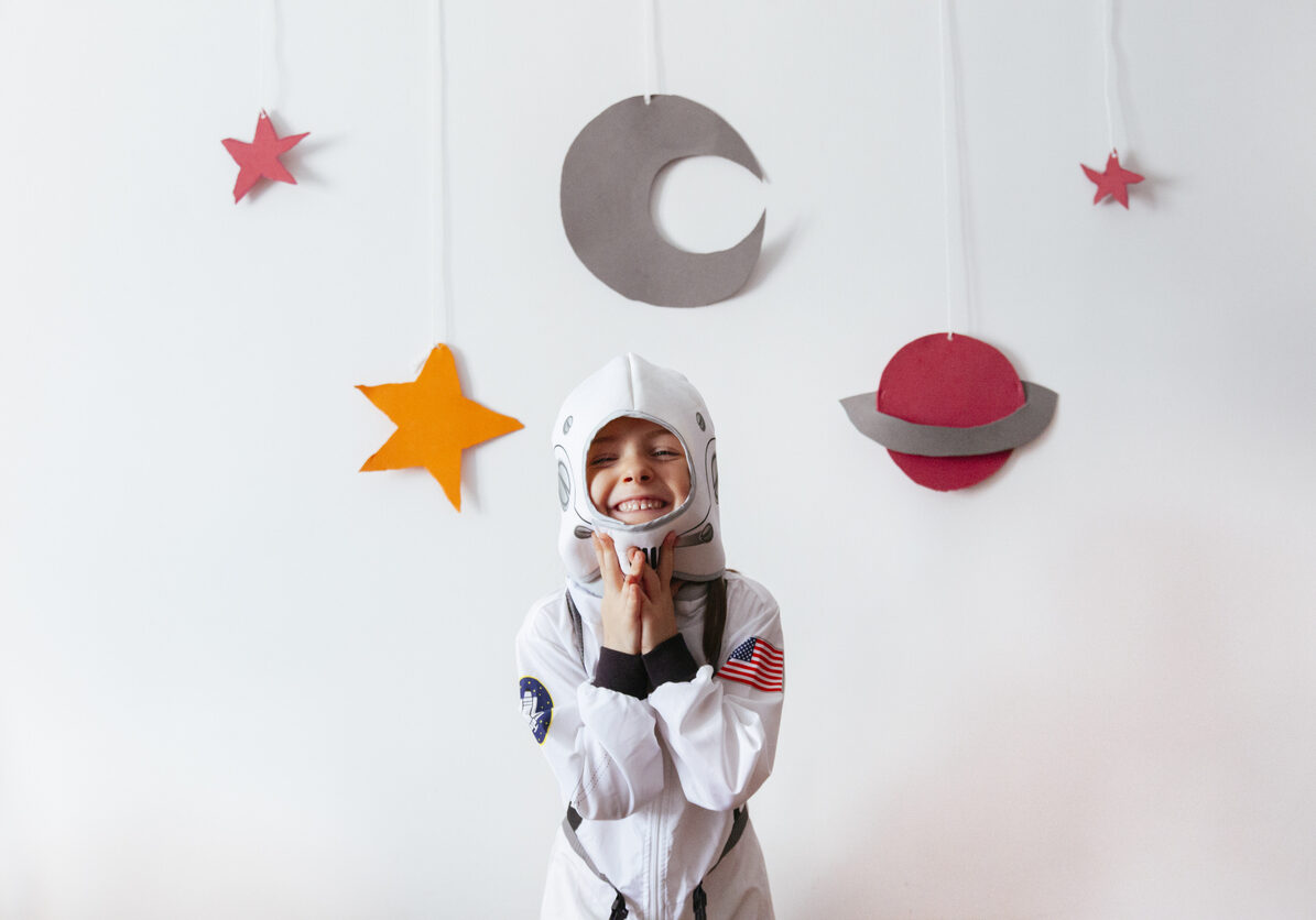 little girl with an astronaut costume at home