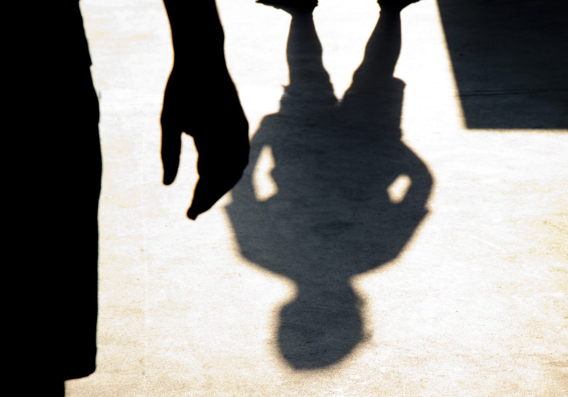 Blurry shadow silhouette of two boys confronting each other