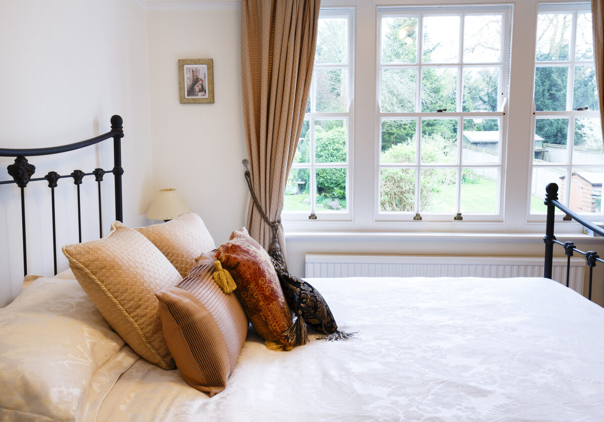 Bedroom of a period British house with sash windows and traditional interior design