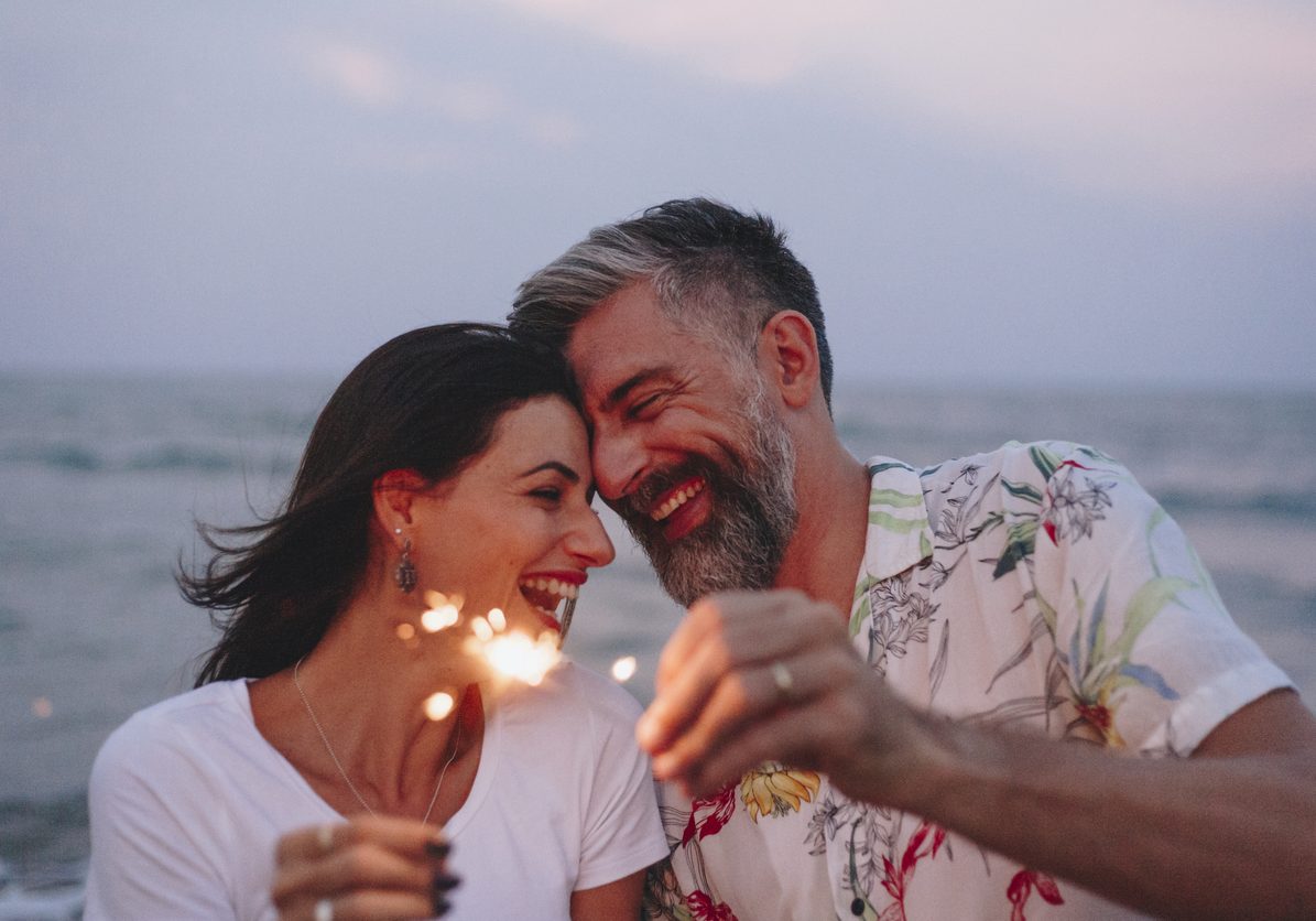 Couple celebrating with sparklers at the beach