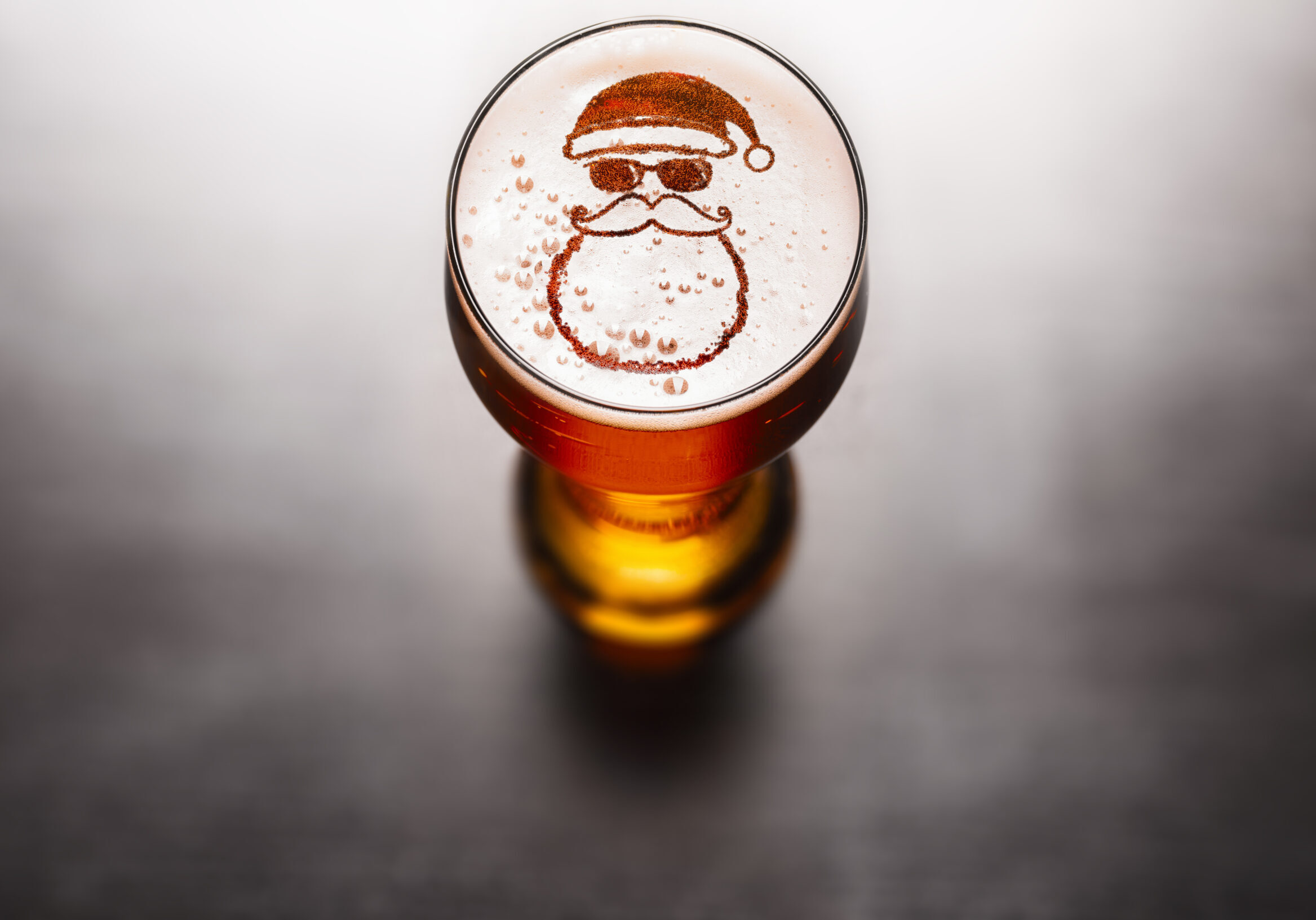 Christmas or New Year beer concept. Star symbol on beer glass foam on black table, view from above