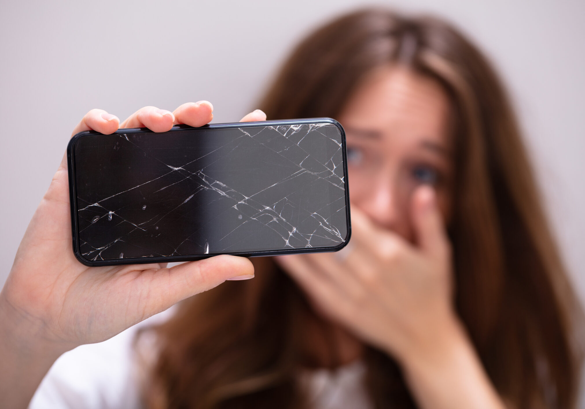 Woman Holding Broken Smartphone