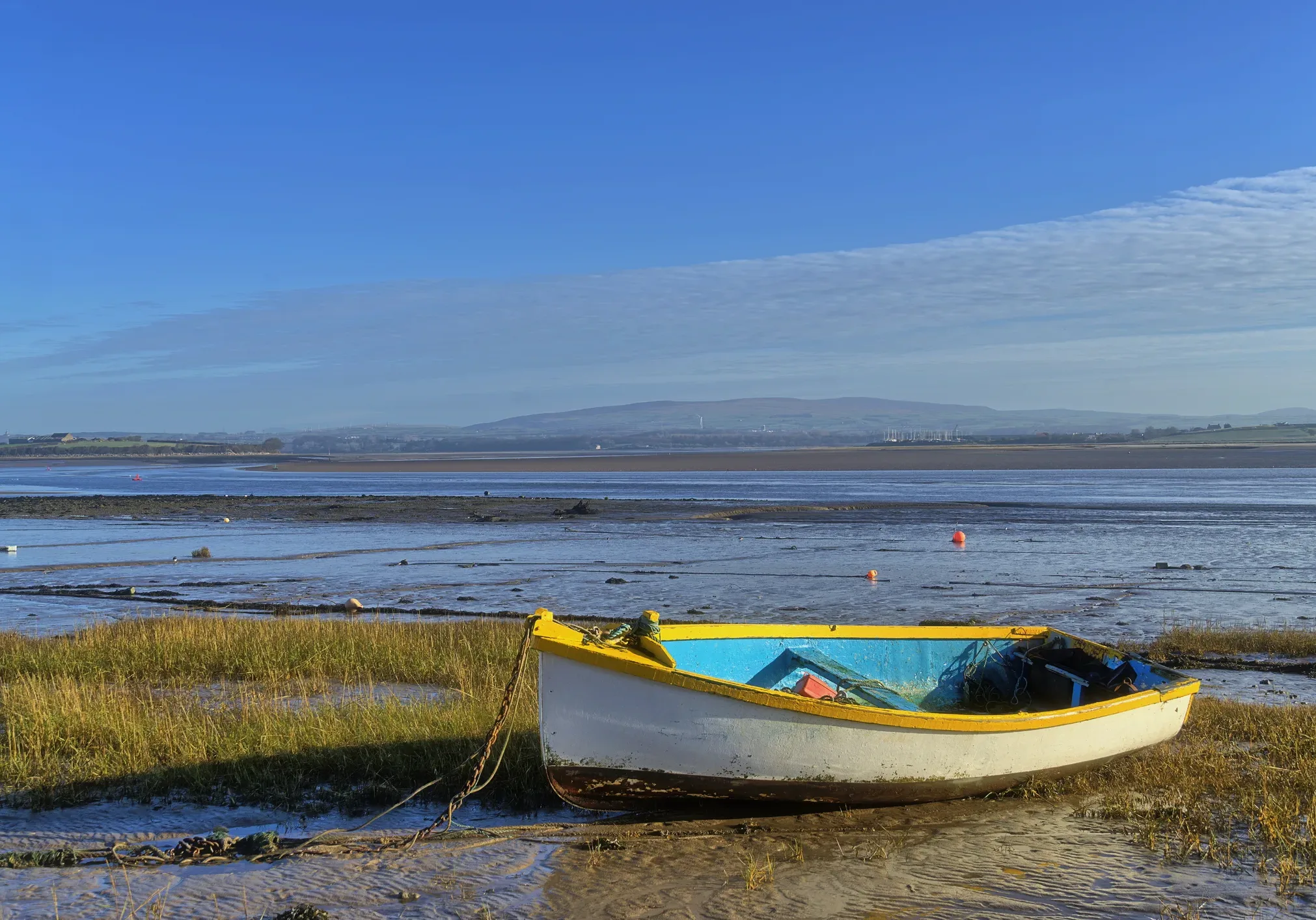 A beached yellow rowing boat, Sunderland Point, Lancashire at low tide.