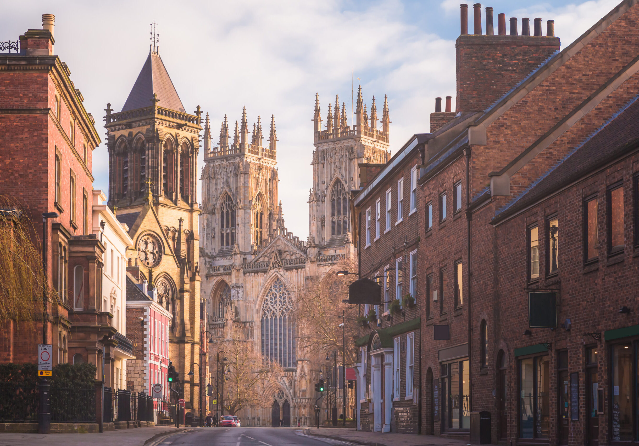 Morning golden light on the historic old town of York along Museum St. looking towards York Minster Cathedral.