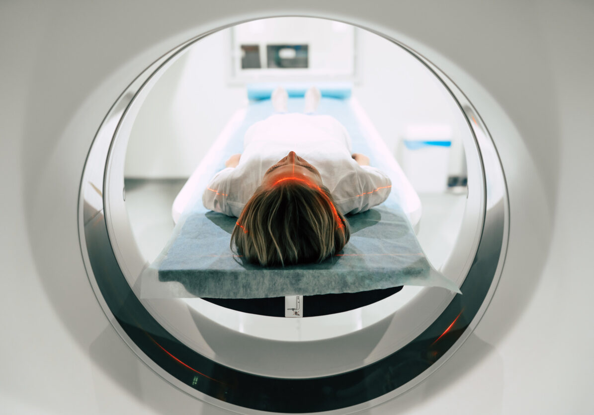 Young woman patient is ready to do magnetic resonance imaging in the modern hospital laboratory