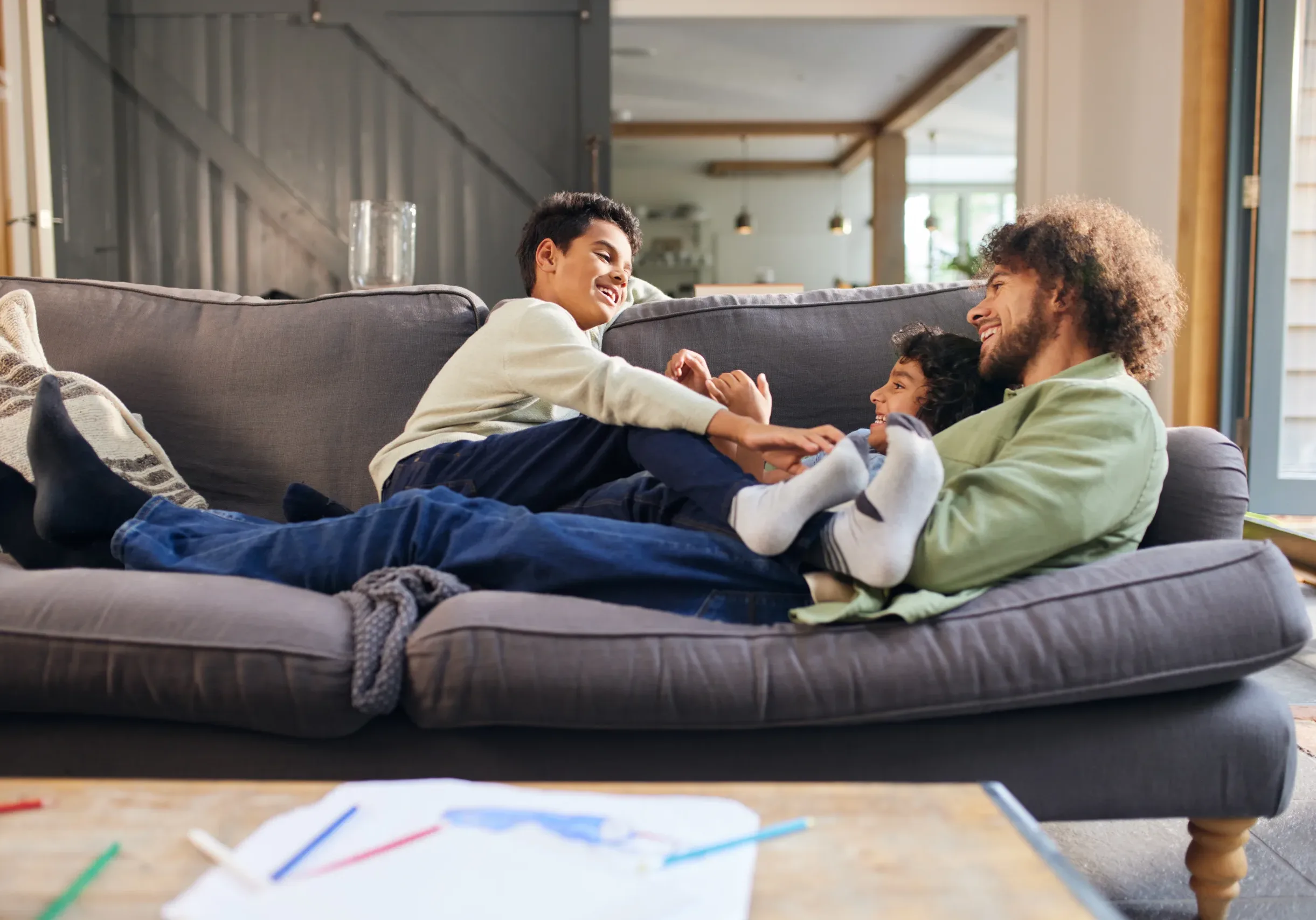 Father and sons relaxing on sofa