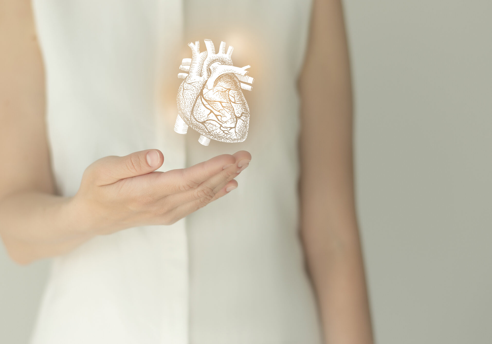 Unrecognizable female patient in white clothes, highlighted handrawn heart in hands. Human heart issues concept.