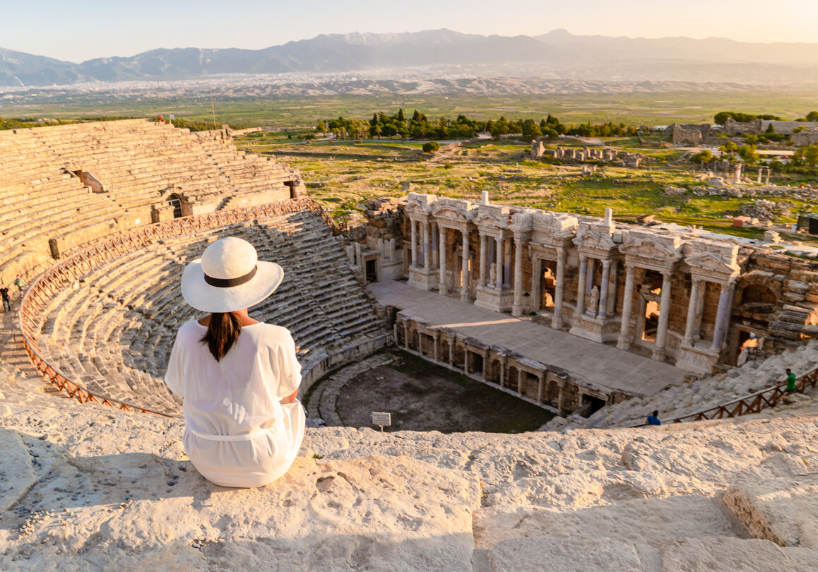 Hierapolis ancient city Pamukkale Turkey, a young Asian woman with a hat watching the sunset by the ruins Unesco site during summer