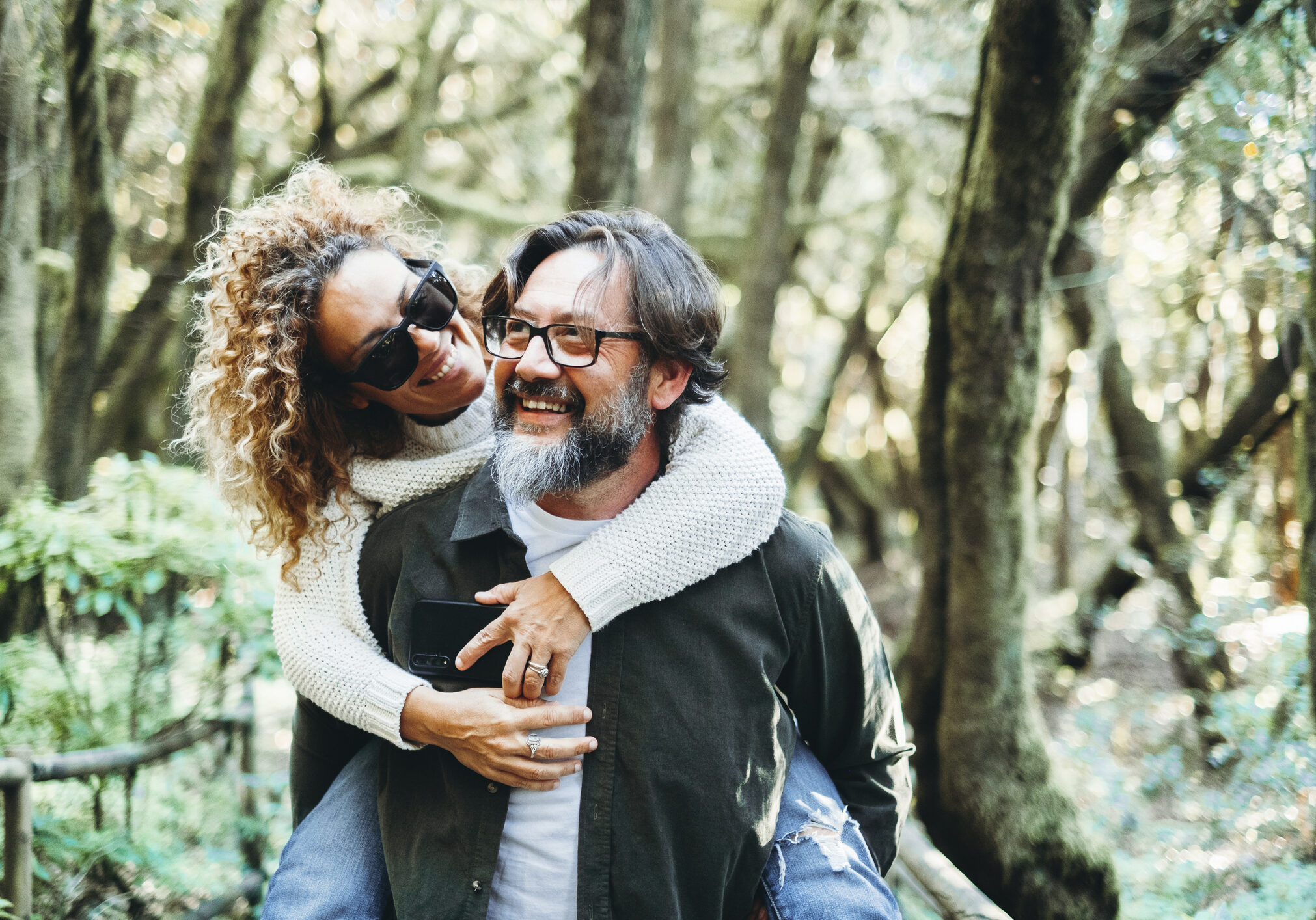 One happy couple enjoy outdoor leisure activity together carrying woman in piggyback and having fun in relationship. Joy people having fun in the nature environment woods weekend travel destination