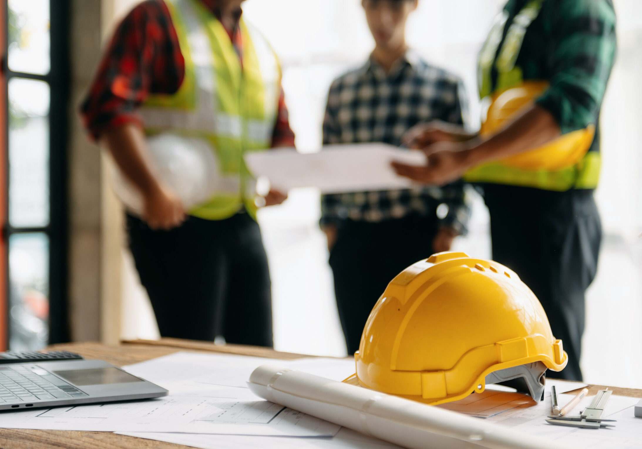 Engineer teams meeting working together wear worker helmets hardhat on construction site in modern city.Asian industry professional team in sun light