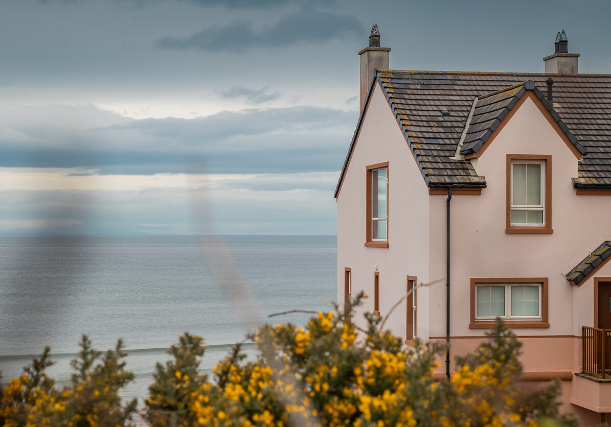 Facade of a typical house in Castlerock, Northern ireland, overlooking the sea or beach on a cloudy rainy morning in spring.