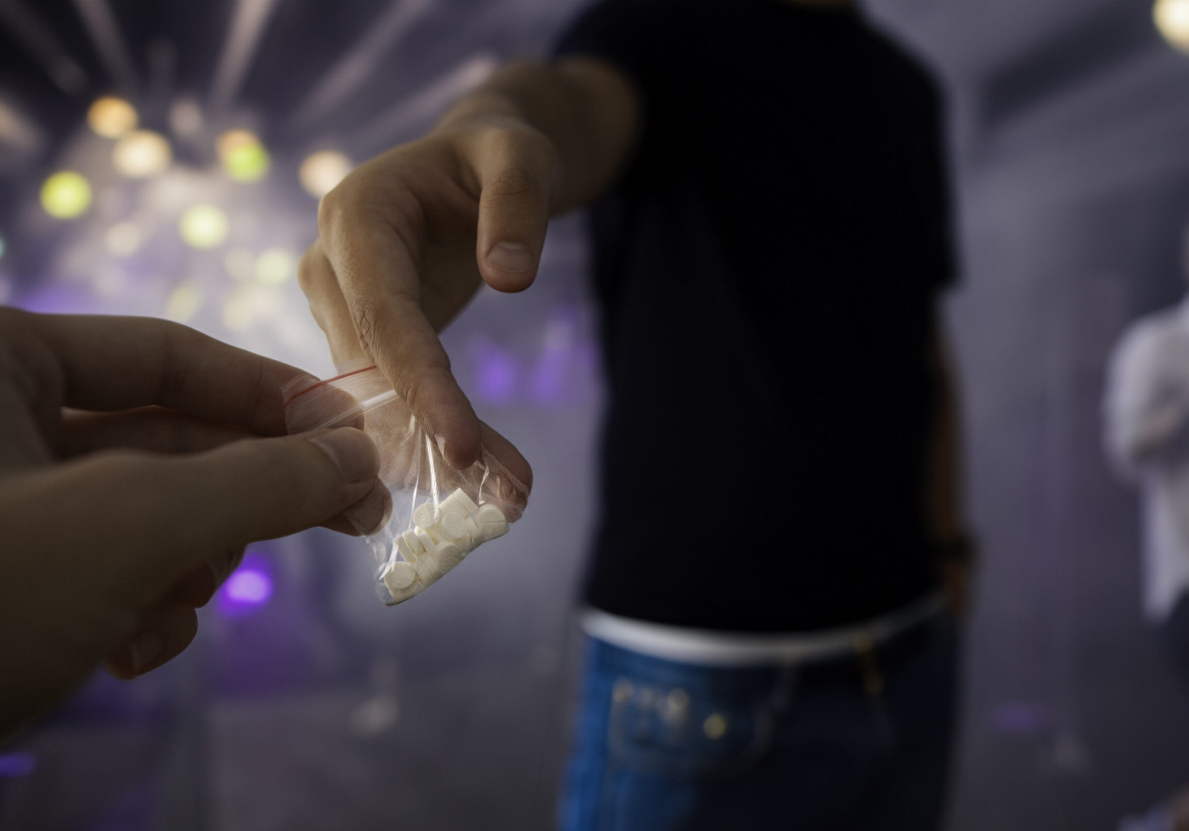 A drug dealer is selling illegal pills at night club