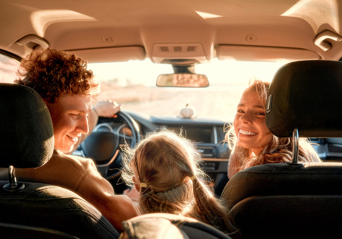 The whole family is driving for the weekend. Mom and Dad with their daughter are sitting in the car. Leisure, travel, tourism.