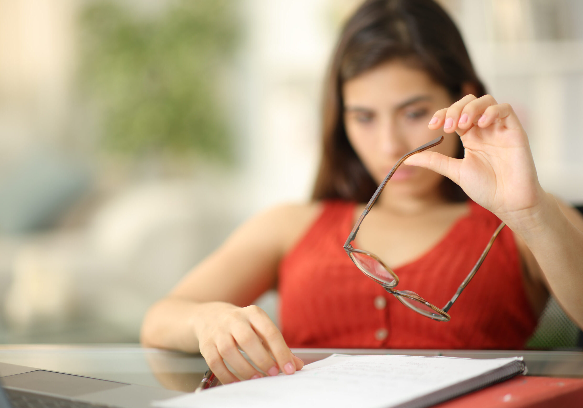 Bored student playing with eyeglasses