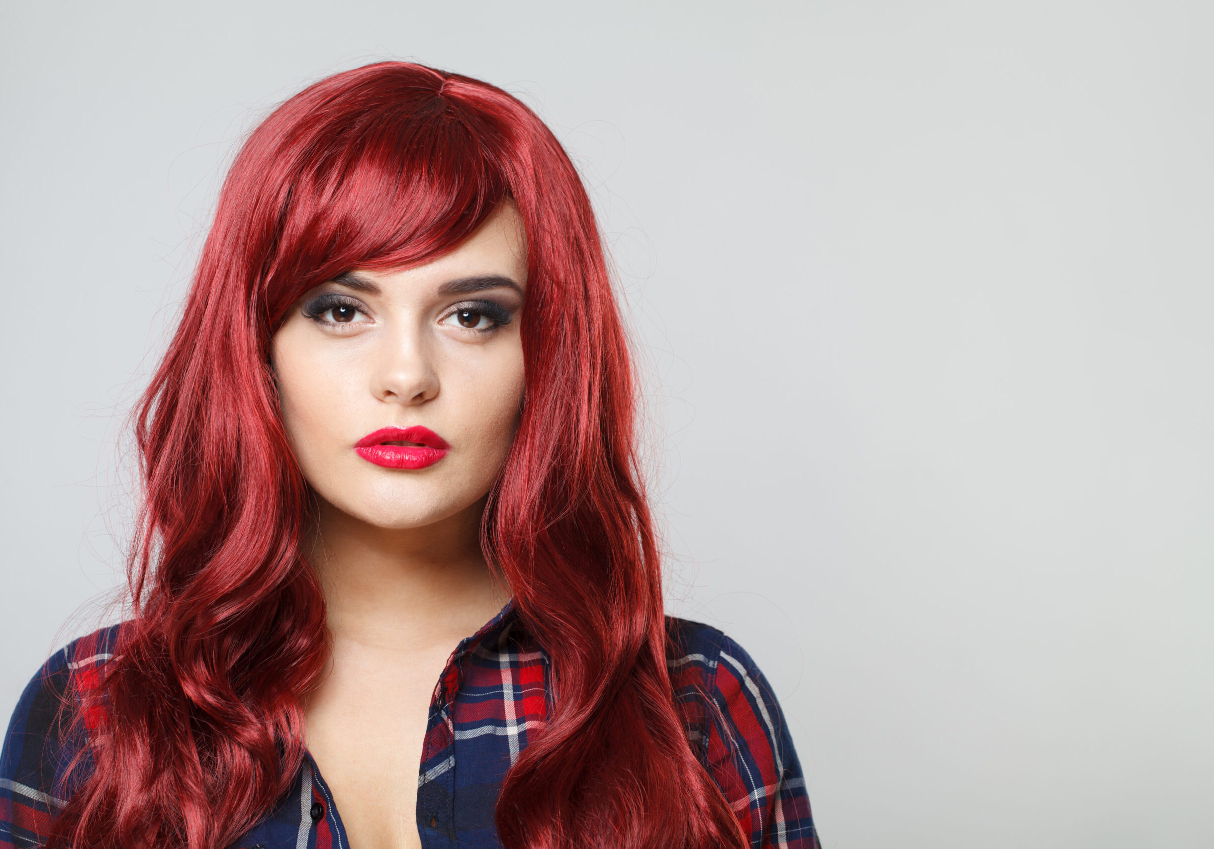 Attractive woman with beautiful long curly red hair on white background