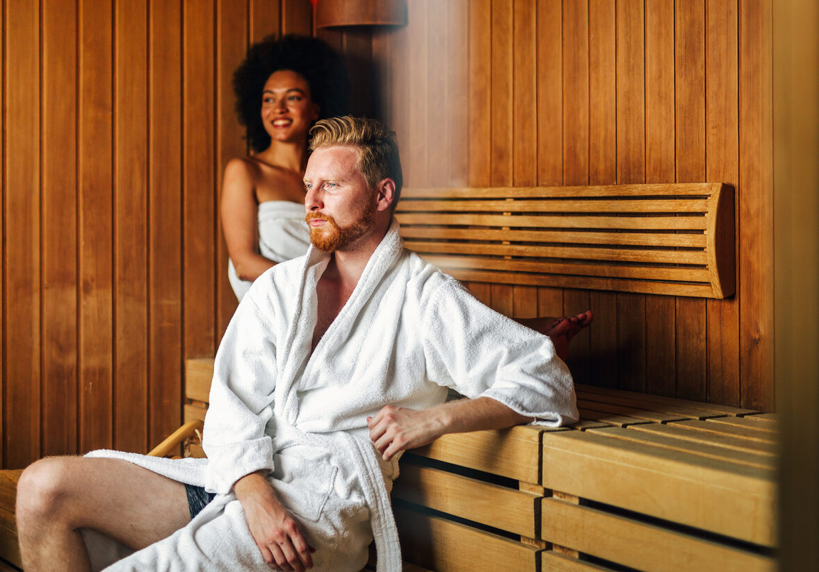 Happy young multiethnic couple enjoying sauna at a spa resort on wellness weekend