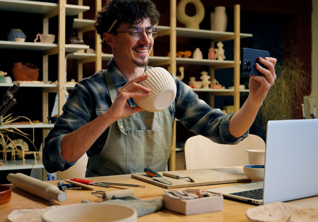 Small business owner Caucasian man guy artist potter salesman blogger influencer mobile phone photo male sculptor craft sale online blog ceramics sell online social media handmade in pottery workshop. High quality 4k footage