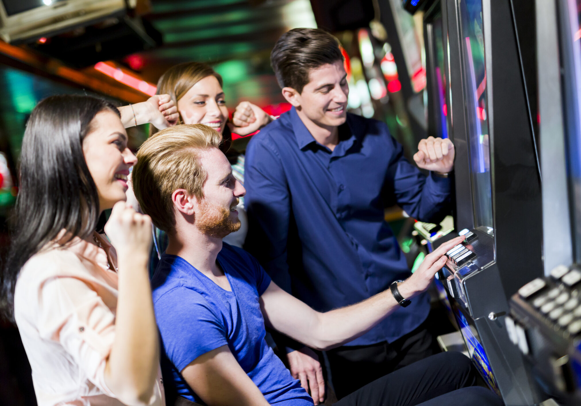 Young group of people gambling in a casino playing slot and various machines