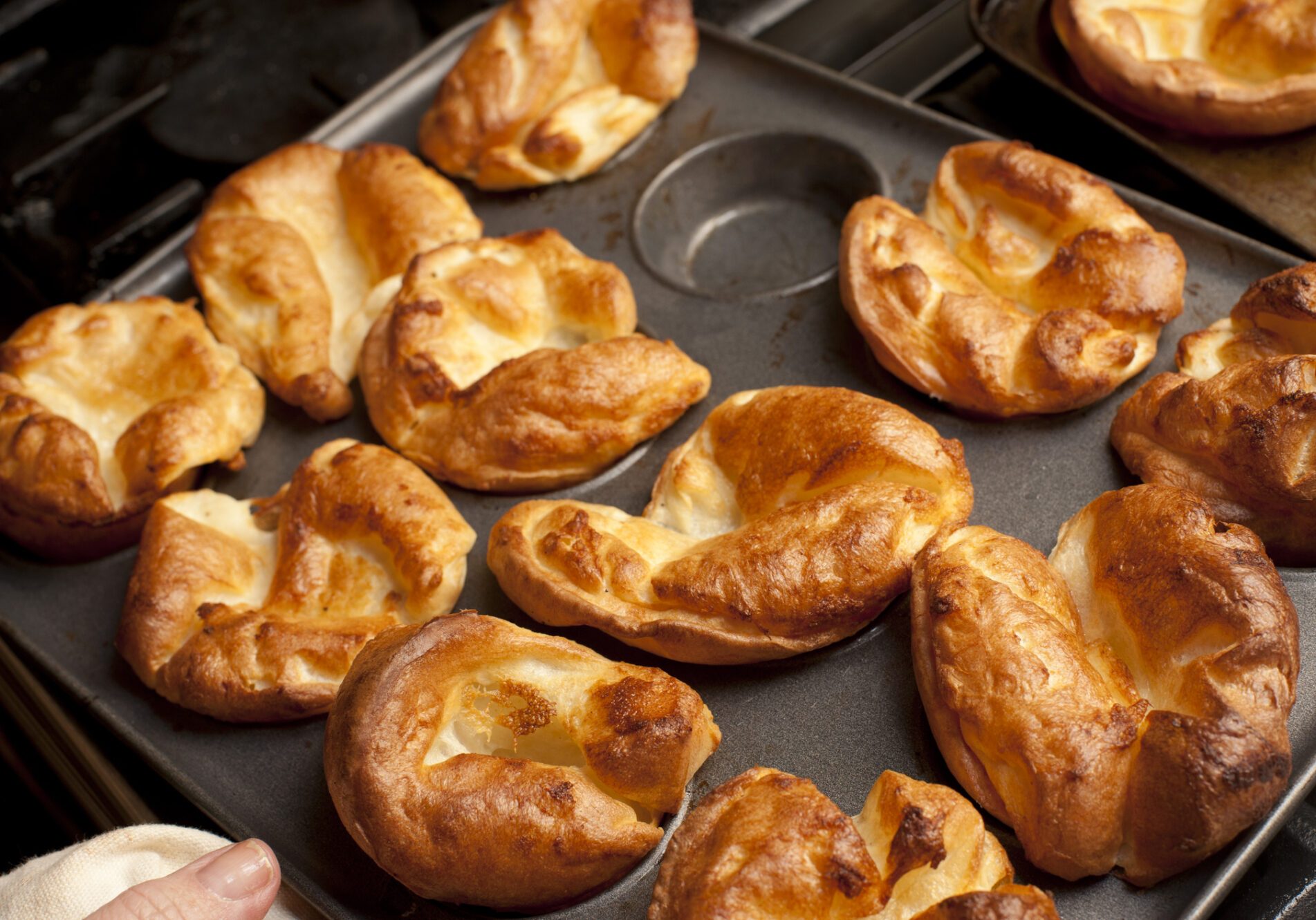 Traditional English Yorkshire puddings made from batter in a baking tray waiting to accompany a meal of roast beef