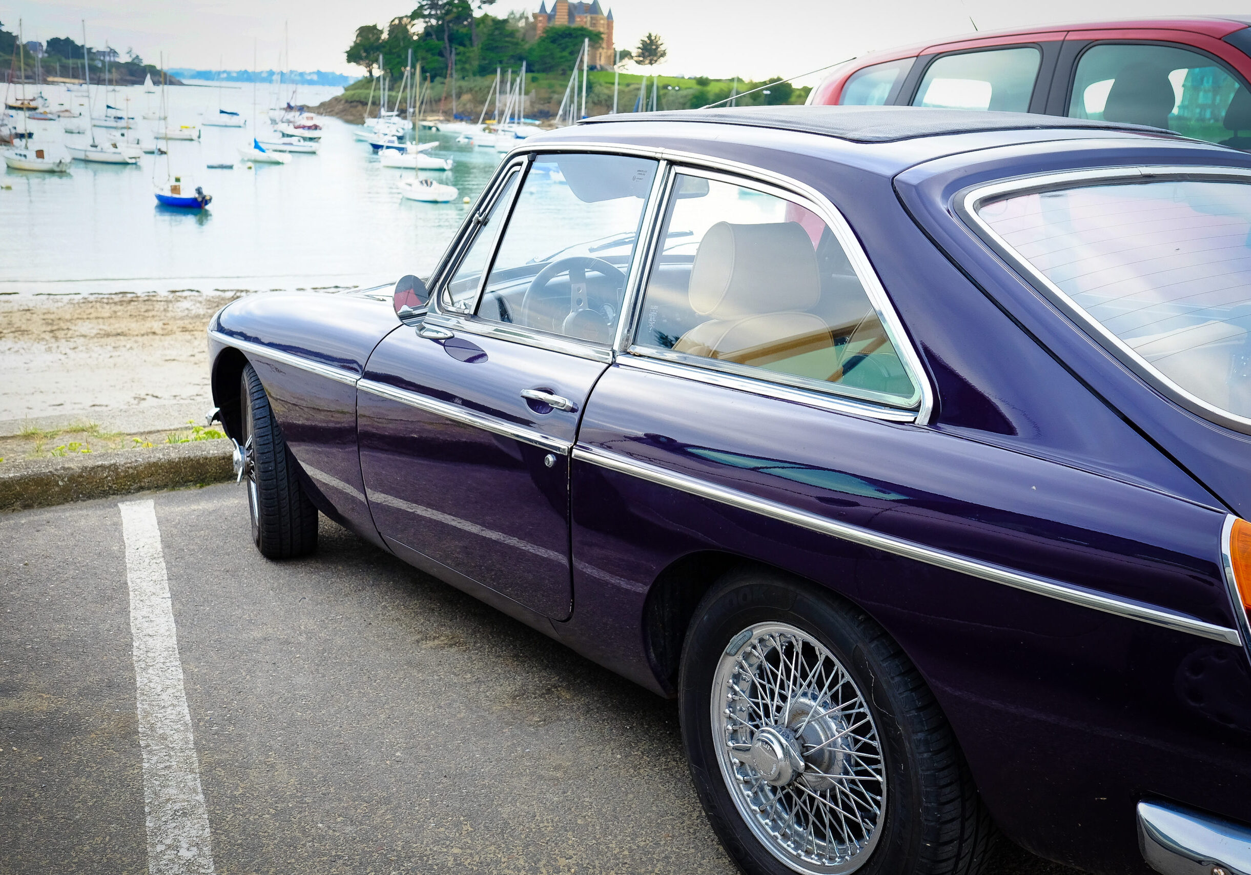 Dark blue vinatge sports car parked near sea