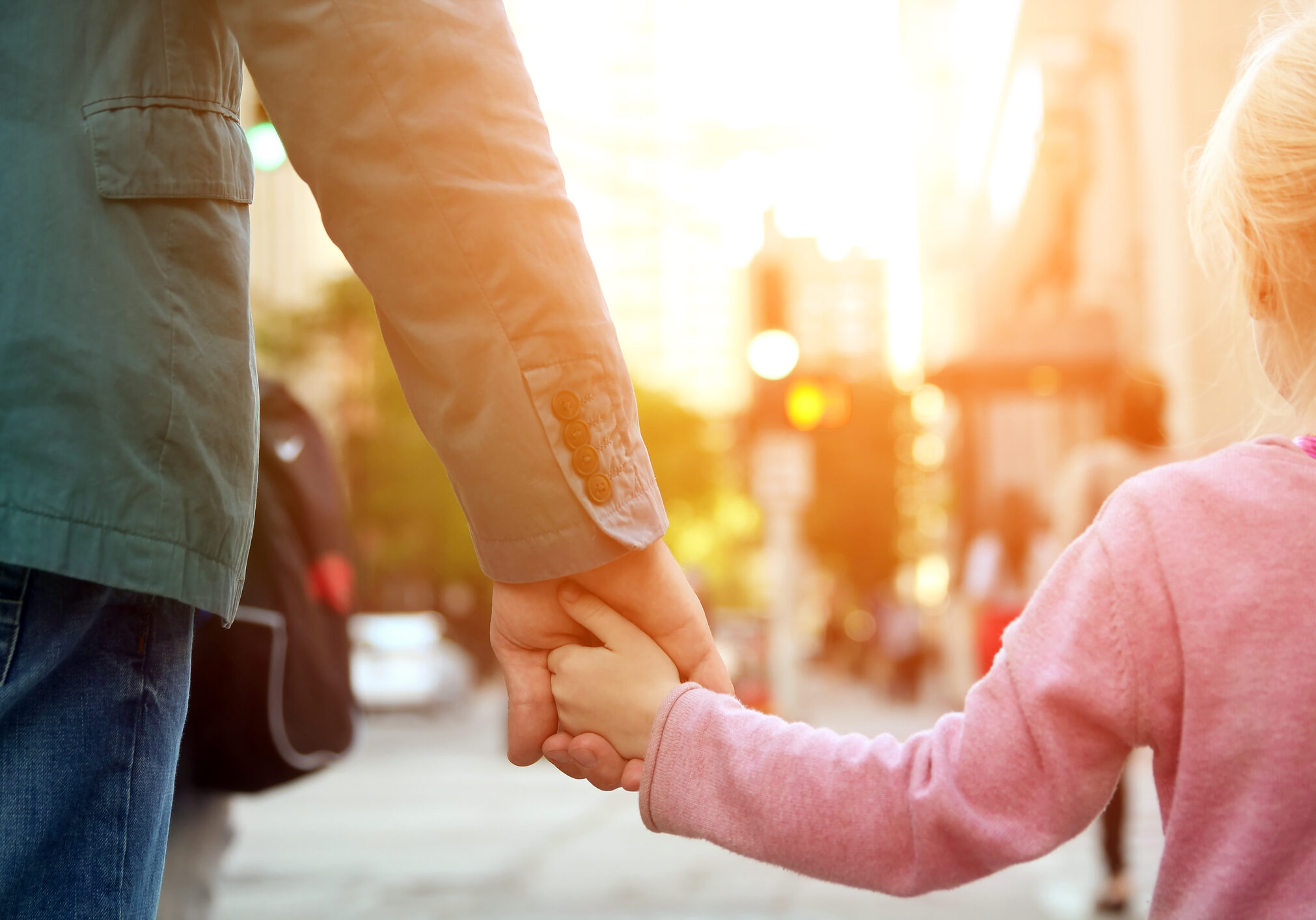 father holding  the daughter/ child  hand  behind  the traffic lights