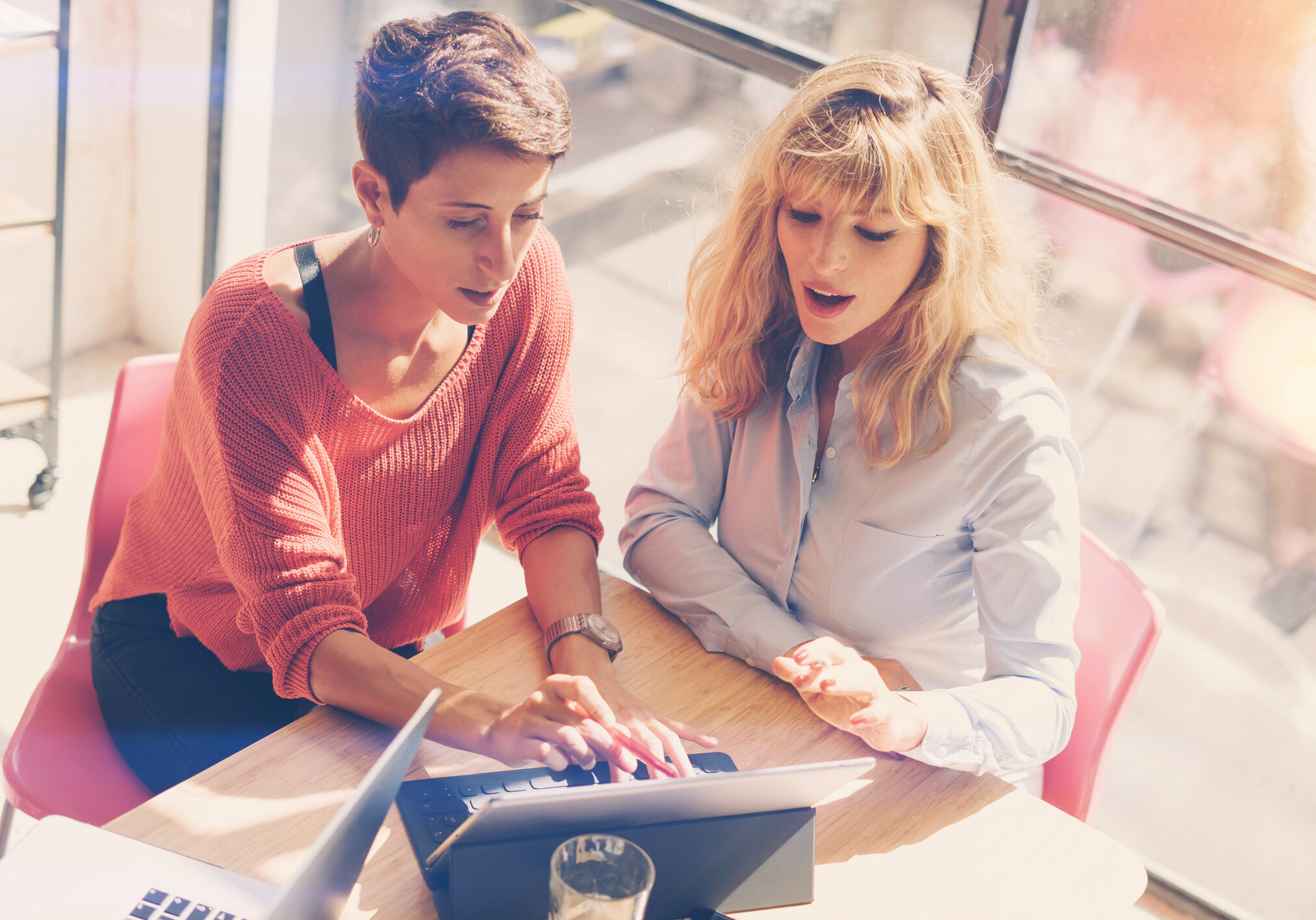 Tow beautiful businesswomen making conversation at modern studio office .Handsome coworkers at working process.Horizontal,blurred