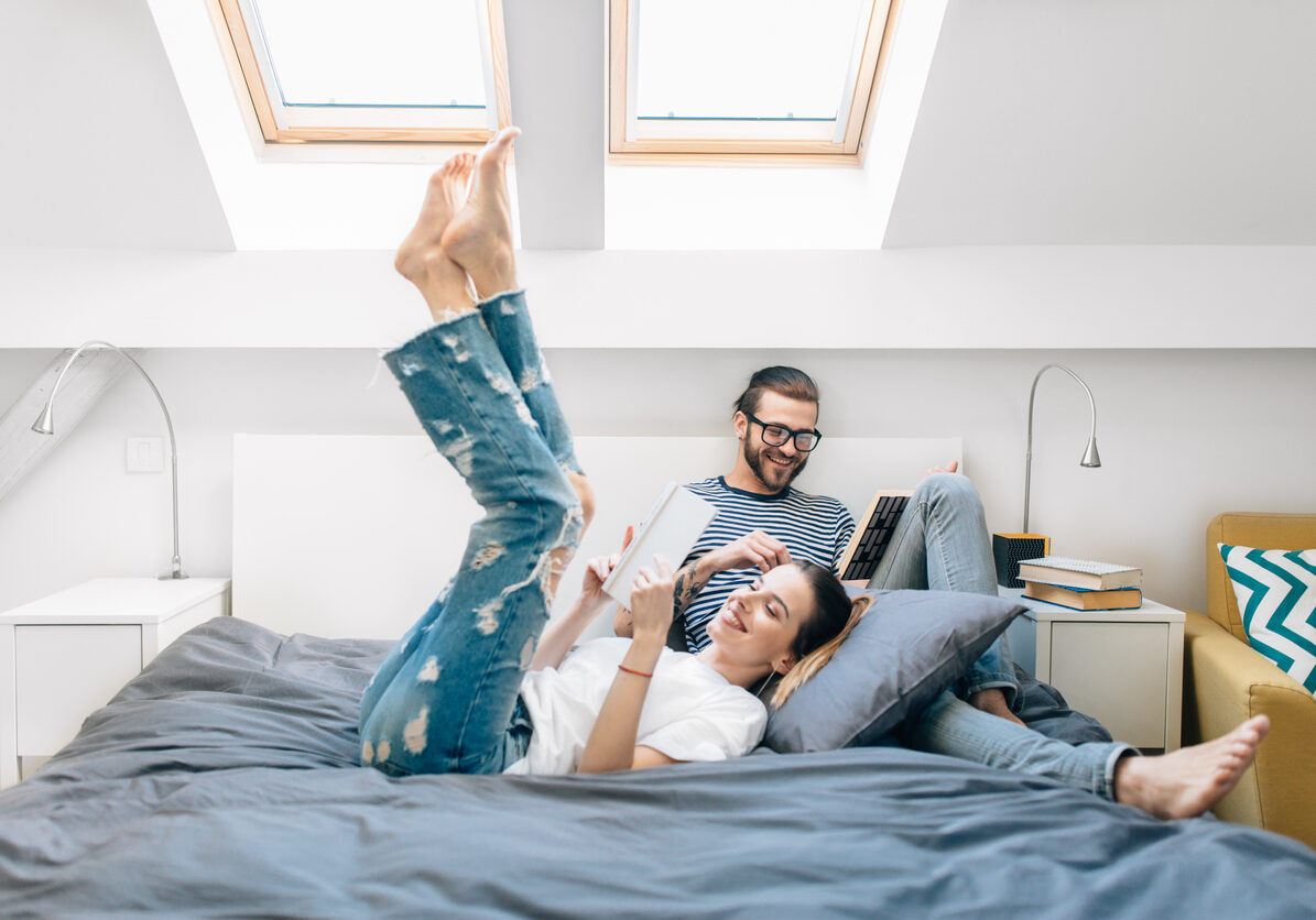 Young couple reading a book in bed
