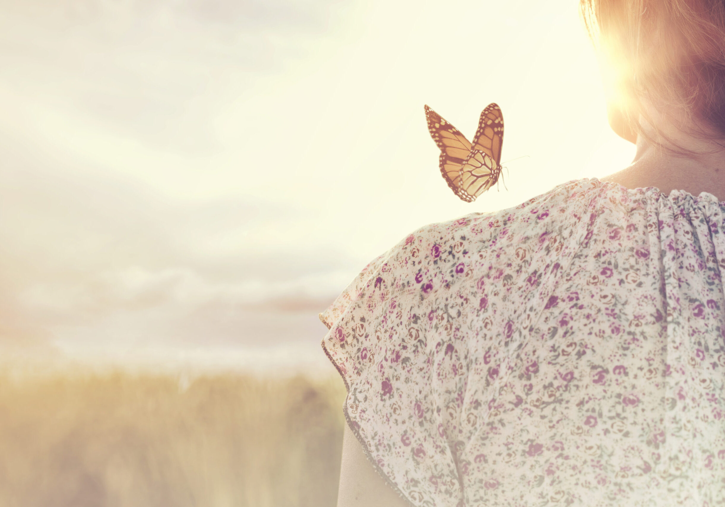 special moment of meeting between a butterfly and a girl in the middle of nature